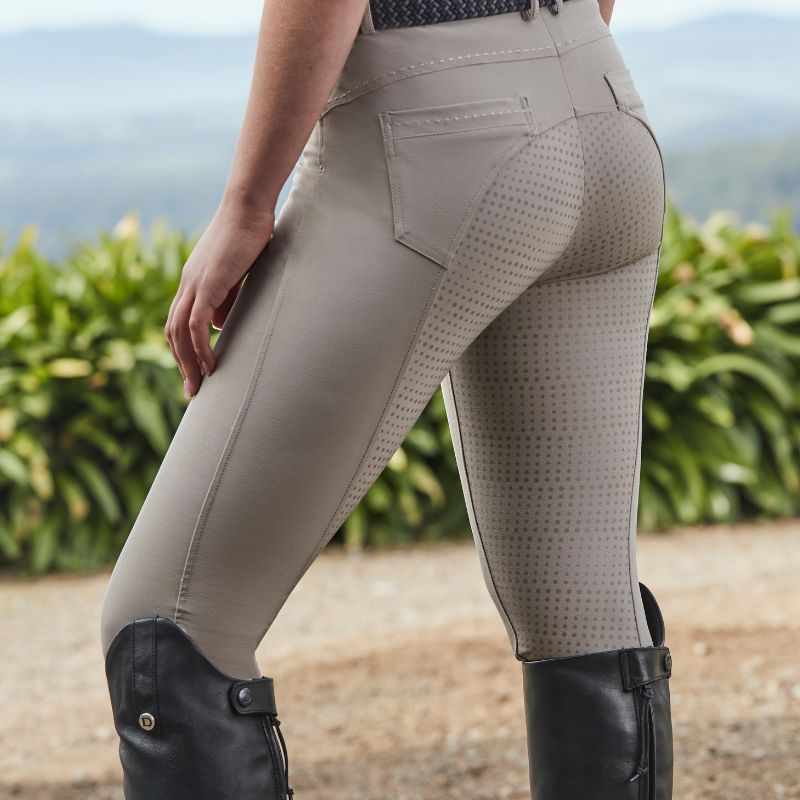 horse rider stood outside wearing beige riding breeches